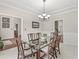 Formal dining room with a glass top table, wooden chairs, wainscoting, and access to multiple rooms at 790 Foxboro Dr, Avon, IN 46123