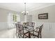 Formal dining room with a glass top table, wooden chairs, wainscoting, and large window with natural light at 790 Foxboro Dr, Avon, IN 46123