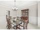 Elegant dining room with a glass top table, wooden chairs, wainscoting, and a decorative china cabinet at 790 Foxboro Dr, Avon, IN 46123