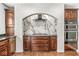 This kitchen offers a white brick archway, custom wood cabinets, granite countertops, and stainless steel appliances at 790 Foxboro Dr, Avon, IN 46123