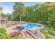 Inviting backyard pool area with comfortable seating, blue umbrellas, beautiful landscaping and wooded backdrop at 790 Foxboro Dr, Avon, IN 46123