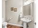 Classic powder room featuring pedestal sink, decorative mirror, and wood-look flooring at 790 Foxboro Dr, Avon, IN 46123