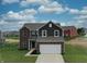 Inviting home showcasing a blend of brick and siding, along with a well-maintained lawn and attached garage at 808 Capricorn Dr, Franklin, IN 46131