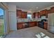 A kitchen showcasing wooden cabinets, tile flooring, and stainless-steel appliances, complemented by a sliding glass door at 808 Capricorn Dr, Franklin, IN 46131