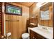 Practical bathroom featuring wood paneling, a vanity, and essential fixtures, providing a tidy space at 8434 S Christian Dr, Nineveh, IN 46164