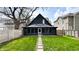Backyard view highlighting a well-maintained lawn and dark siding of the home's back exterior at 909 N Temple Ave, Indianapolis, IN 46201