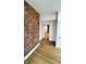Hallway with hardwood floors and exposed brick accent wall at 909 N Temple Ave, Indianapolis, IN 46201