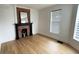 Bright room featuring a decorative brick fireplace, large window, and hardwood flooring at 909 N Temple Ave, Indianapolis, IN 46201