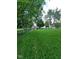 Well-maintained, grassy backyard with a black chain-link fence, lush trees, and a rope swing at 922 Eagle Brook Dr, Shelbyville, IN 46176