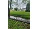 View of backyard with stream and lush lawn, seen through a wrought iron fence at 922 Eagle Brook Dr, Shelbyville, IN 46176