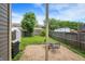 Backyard area featuring brick patio with grill, table, and chairs, enclosed by fence, and surrounded by mature trees at 925 Fayette St, Indianapolis, IN 46202