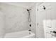 Elegant bathroom with a tub, white marble tile surround, and matte black shower fixture at 925 Fayette St, Indianapolis, IN 46202