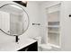 Stylish bathroom featuring white vanity, round mirror, modern fixtures, and a window providing natural light at 925 Fayette St, Indianapolis, IN 46202