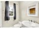 Cozy powder room featuring a pedestal sink, toilet, and a window for natural light at 925 Fayette St, Indianapolis, IN 46202