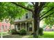 Charming two-story home with a cozy front porch and mature trees, providing a welcoming curb appeal at 925 Fayette St, Indianapolis, IN 46202