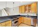 Modern kitchen with stainless steel appliances, wooden cabinets, and a view of the staircase at 925 Fayette St, Indianapolis, IN 46202