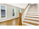 Sun-filled living room featuring wood floors, staircase, and large windows at 925 Fayette St, Indianapolis, IN 46202