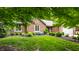 Well-maintained brick home with lovely landscaping, mature trees, and a lush green lawn at 9445 Moorings Blvd, Indianapolis, IN 46256
