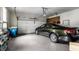 Spacious garage with epoxy flooring, storage shelving and an elegant dark green car at 9445 Moorings Blvd, Indianapolis, IN 46256