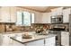 Bright kitchen featuring stone countertops, stainless appliances and bright white cabinets at 9445 Moorings Blvd, Indianapolis, IN 46256