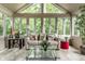Bright sunroom with tiled floor, large windows and comfortable seating area surrounded by lush greenery at 9445 Moorings Blvd, Indianapolis, IN 46256