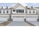 Charming white townhouse featuring a spacious garage, black shutters, and stylish dormer windows at 9741 Oleander Dr, Fishers, IN 46250