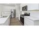 Modern kitchen with stainless steel appliances, white cabinets, and stylish backsplash at 9741 Oleander Dr, Fishers, IN 46250