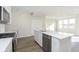 Kitchen island with stainless steel dishwasher, sink, and faucet with adjacent living room at 9741 Oleander Dr, Fishers, IN 46250