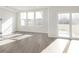 Living room with patio door leading to outdoor deck and three large windows at 9741 Oleander Dr, Fishers, IN 46250