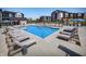 Luxury apartment community pool area featuring ample lounge chairs and umbrellas under a clear sky at 9741 Oleander Dr, Fishers, IN 46250