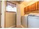 Well lit laundry room with wooden cabinets, washer and dryer and a window at 977 Canary Creek Dr, Franklin, IN 46131