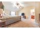 Bright main bedroom featuring a ceiling fan, television, and access to the ensuite bathroom at 977 Canary Creek Dr, Franklin, IN 46131