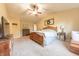 This main bedroom features a wooden bed frame, ceiling fan, and access to ensuite bathroom at 977 Canary Creek Dr, Franklin, IN 46131