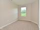 Bedroom with neutral walls and carpeting and a bright window providing natural light and a view of greenery at 10431 Bellchime Ct, Indianapolis, IN 46235