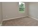 Bedroom with carpeted flooring, light-colored walls and a window overlooking a pleasant view of trees at 10431 Bellchime Ct, Indianapolis, IN 46235