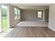 Bright living room with hardwood flooring, with sliding glass door to the green lawn and natural light at 10431 Bellchime Ct, Indianapolis, IN 46235