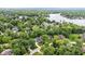 This aerial shot shows the beautiful, quiet neighborhood near a lake surrounded by lush trees at 11227 Woods Bay Ln, Indianapolis, IN 46236