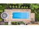 An aerial view of a backyard pool with a diving board, fire pit, and landscaping with greenery and trees at 11227 Woods Bay Ln, Indianapolis, IN 46236
