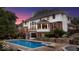 A backyard pool and deck area is surrounded by a home exterior with a brick and wood exterior with steps and landscaping at 11227 Woods Bay Ln, Indianapolis, IN 46236