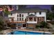 A backyard pool and deck area is surrounded by a home exterior with a brick and wood exterior with steps and landscaping at 11227 Woods Bay Ln, Indianapolis, IN 46236