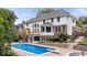 A backyard pool and deck area is surrounded by a home exterior with a brick and wood exterior with steps and landscaping at 11227 Woods Bay Ln, Indianapolis, IN 46236