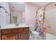 Bathroom with floral shower curtain, marble counter and wood cabinets at 11227 Woods Bay Ln, Indianapolis, IN 46236