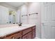 Bathroom with white countertop, wooden cabinets, large mirror, and updated fixtures at 11227 Woods Bay Ln, Indianapolis, IN 46236