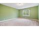 Neutral bedroom with carpet, green walls, and a bright window at 11227 Woods Bay Ln, Indianapolis, IN 46236