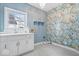Bright laundry room features charming floral wallpaper, a utility sink, and modern tile flooring at 11227 Woods Bay Ln, Indianapolis, IN 46236