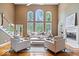 Spacious living room with hardwood floors, tall windows, and a fireplace at 11227 Woods Bay Ln, Indianapolis, IN 46236