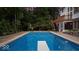 A rectangular swimming pool with a diving board is surrounded by a well-manicured lawn and landscaping at 11227 Woods Bay Ln, Indianapolis, IN 46236