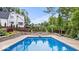 An in-ground pool features a diving board, stone retaining wall and landscaping with a distant view of the home at 11227 Woods Bay Ln, Indianapolis, IN 46236