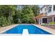 A rectangular swimming pool with a diving board is surrounded by a well-manicured lawn and landscaping at 11227 Woods Bay Ln, Indianapolis, IN 46236