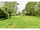 Expansive backyard with lush green grass and mature trees, perfect for outdoor activities at 11309 N County Road 750 W, Elwood, IN 46036
